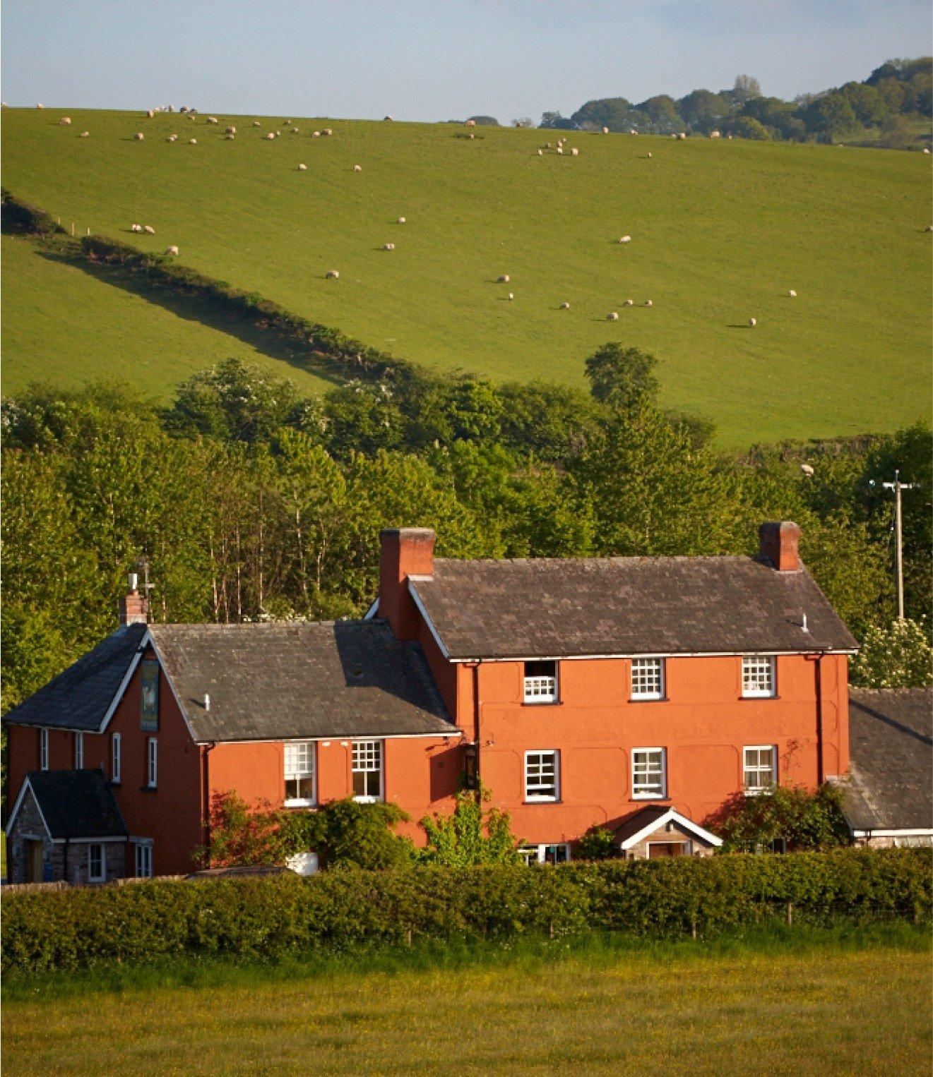 a large red house with a green field in the background